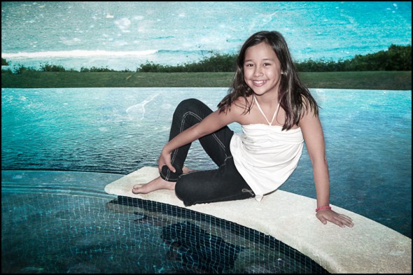 Young Girl On Edge of Hot Tub with Pool and Ocean in Background